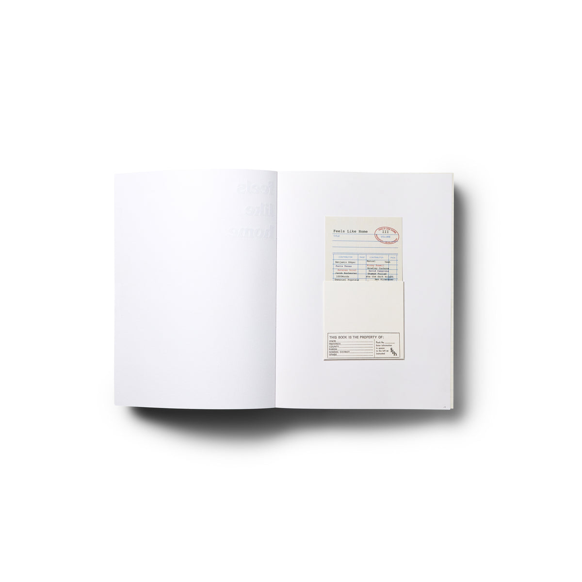 Open book showing a mostly white interior spread with a small card inserted on the right page